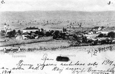 Foto legenda: Stara anzist karta (dopisnica) prikazuje deo panorame starog Kruševca slikan sa obronka Bagdale. Jasno se primećuje jedno od najlepših zdanja u Srbiji – stara Gimnazija (Narodni muzej). Rukopis pripada izvesnom Đorđu Božiloviću, koji jednoj dami čestita Novu 1901. godinu i ulazak u novi vek.